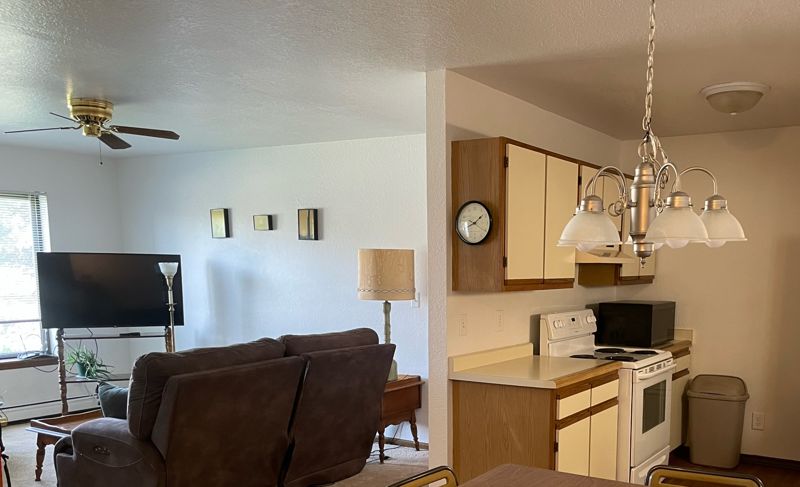 Open living room and dining area with ceiling fan and kitchen beyond